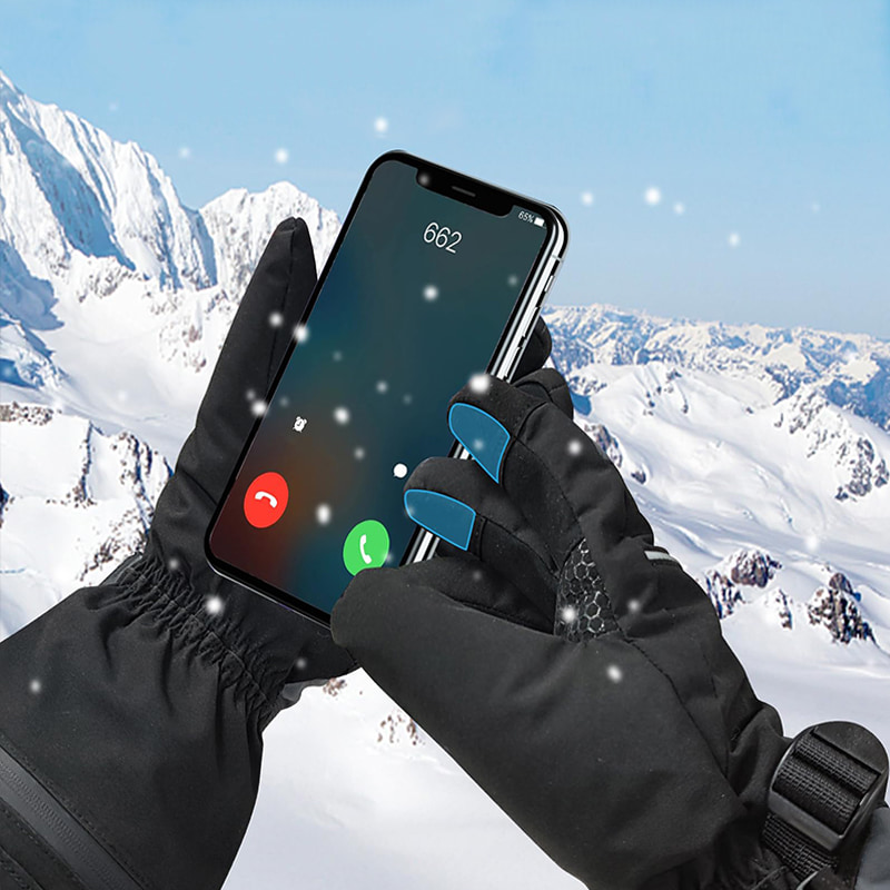 Wearing heated gloves operating touchscreen smartphone in snowy mountain conditions